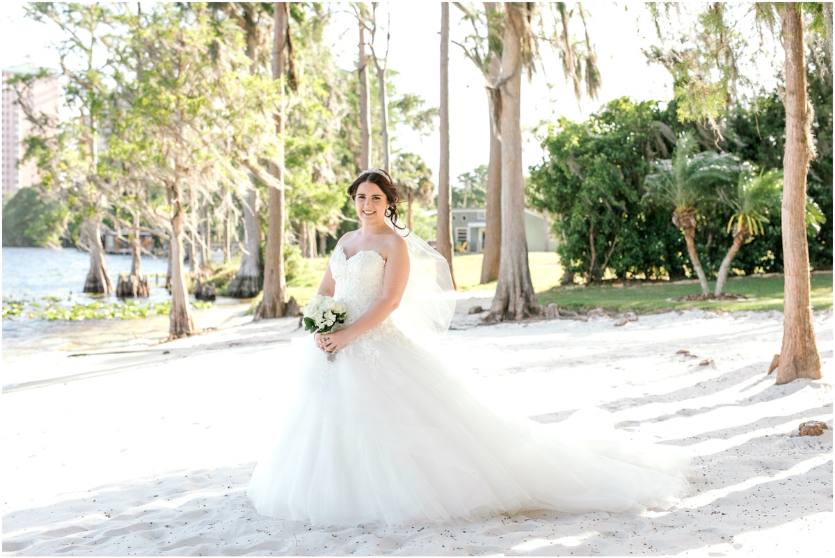 Bride on the sand in her princess style wedding dress. 