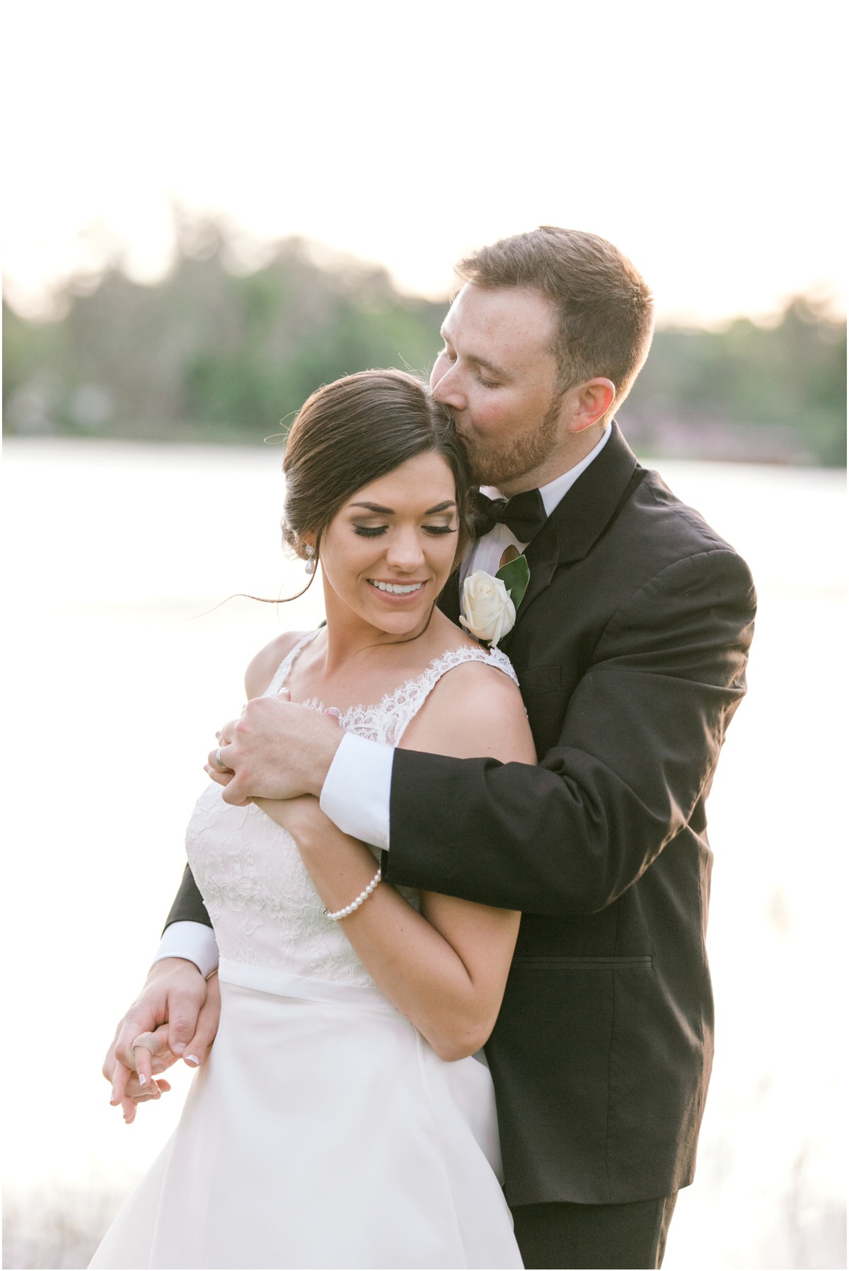 Bride and groom by the lake at sunset for their citrus inspired Florida wedding.