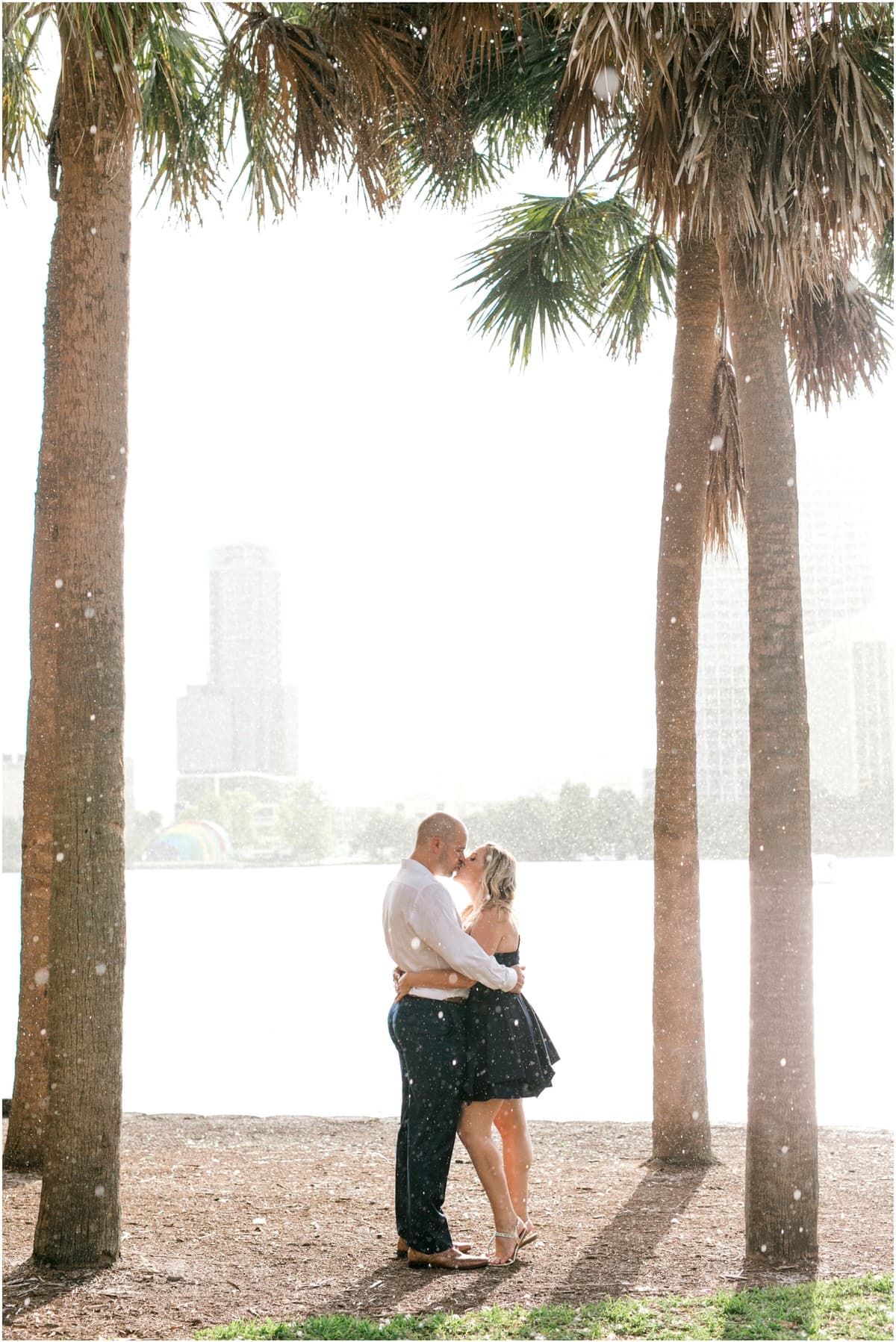 Downtown Orlando Engagement Session couple kissing in the rain under trees