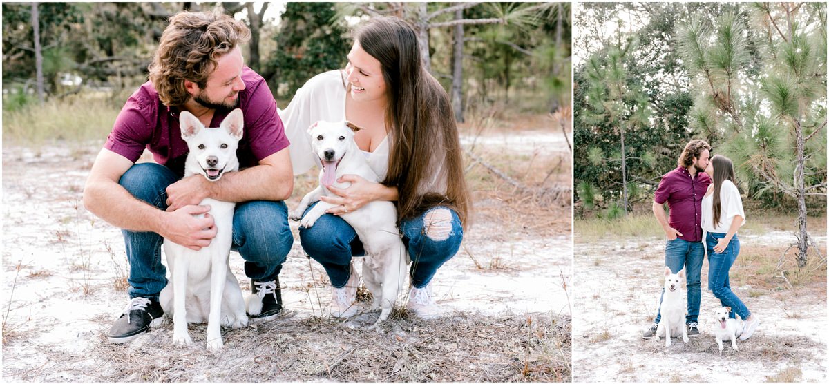 couple posing in woods with two white dogs