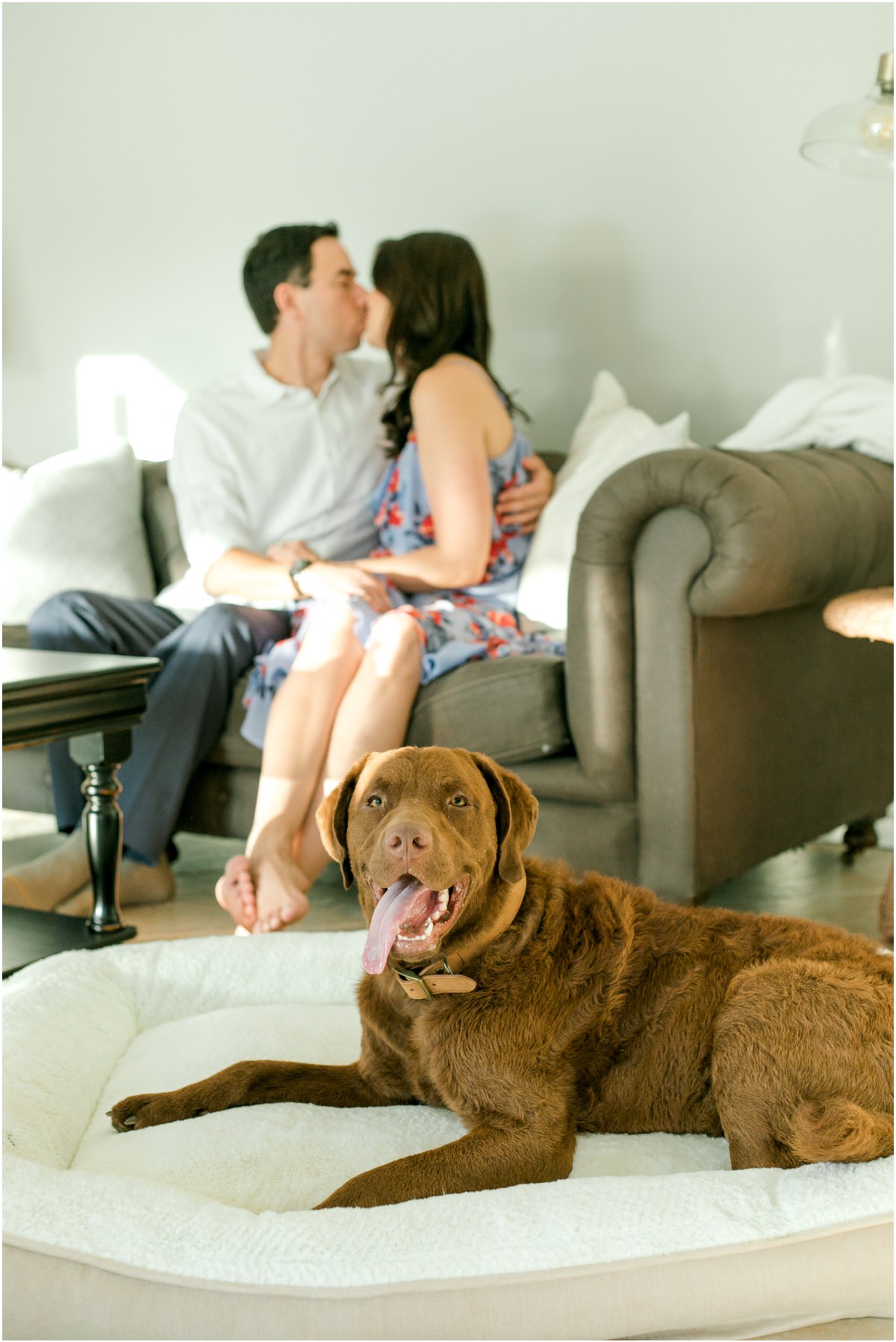 guy and girl kissing on the couple with their dog on the floor next to them