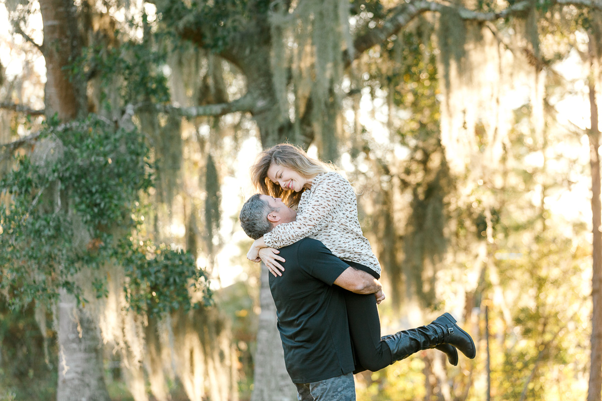 Guy holding girl in the air at engagement session