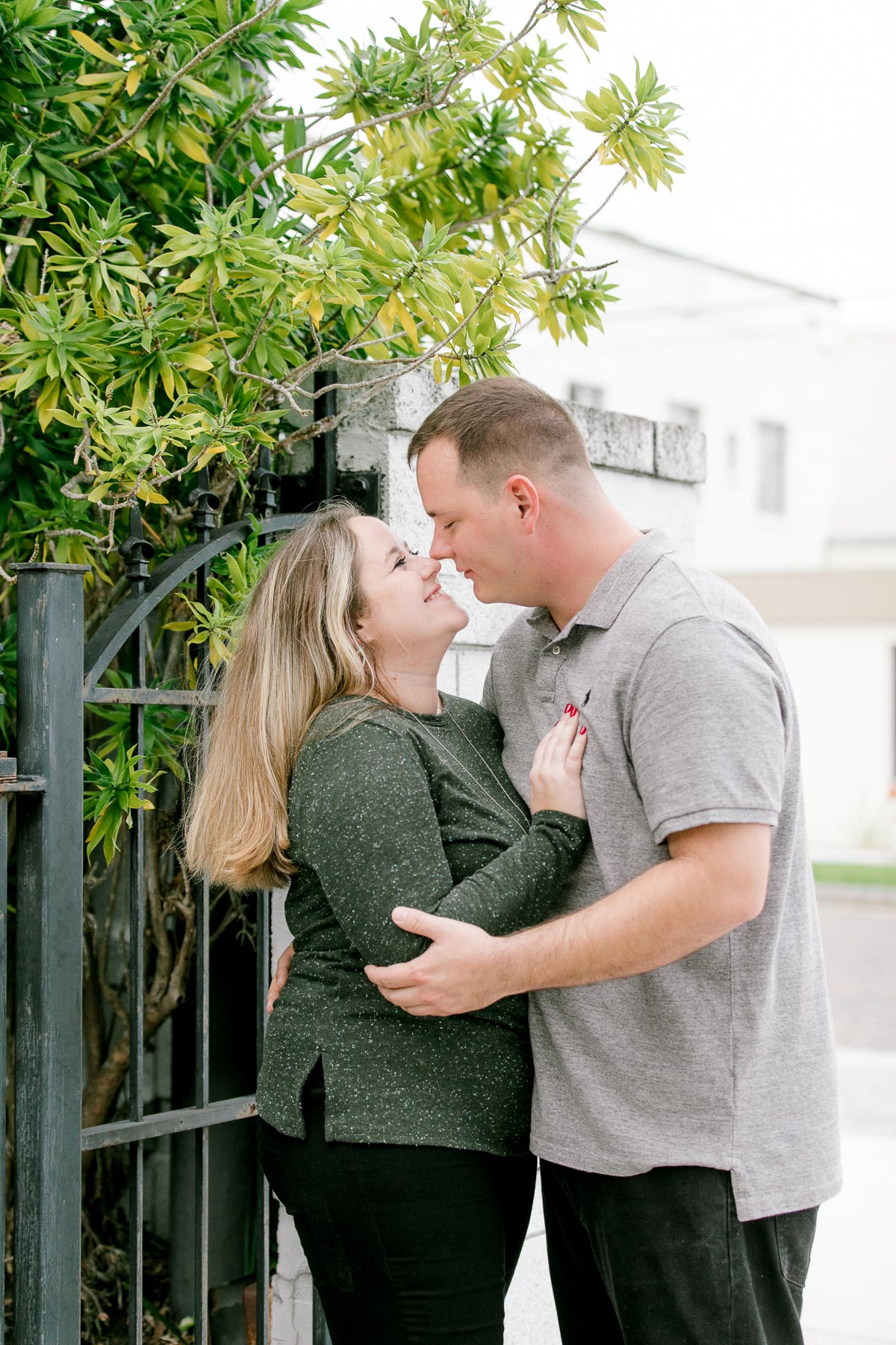 Woman kisses fiancé on the cheek at engagement session