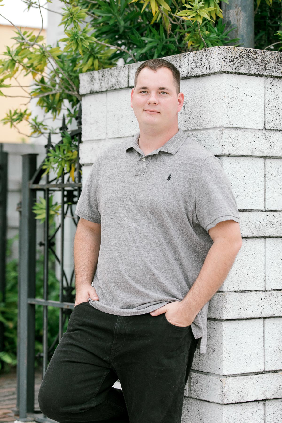Portrait of a guy in gray polo shirt and black pants at engagement session