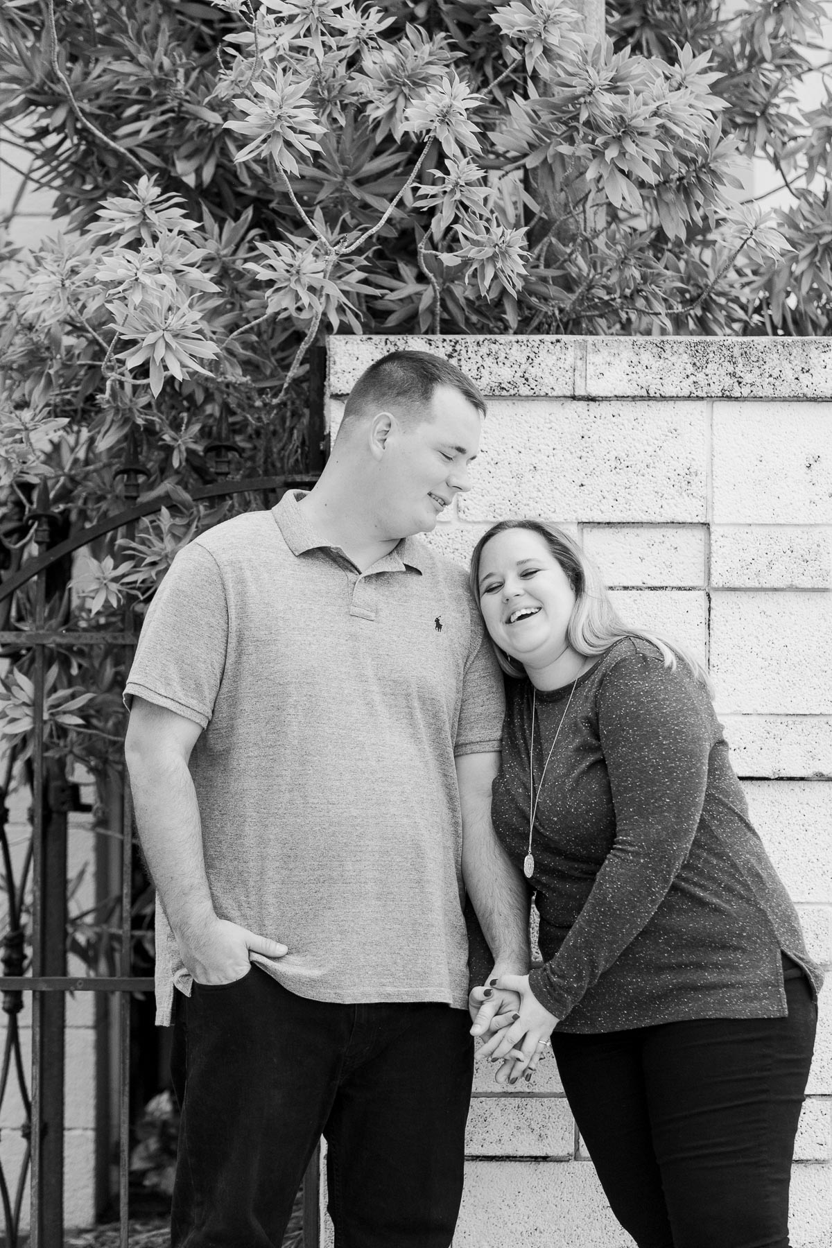 Black and white photo of couple laughing and holding hands. 