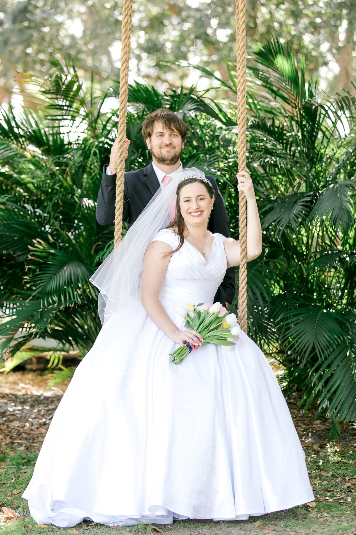 bride and groom taking photos on a swing.