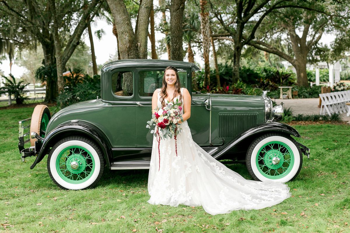Bride in vintage lace wedding dress standing in front of truck