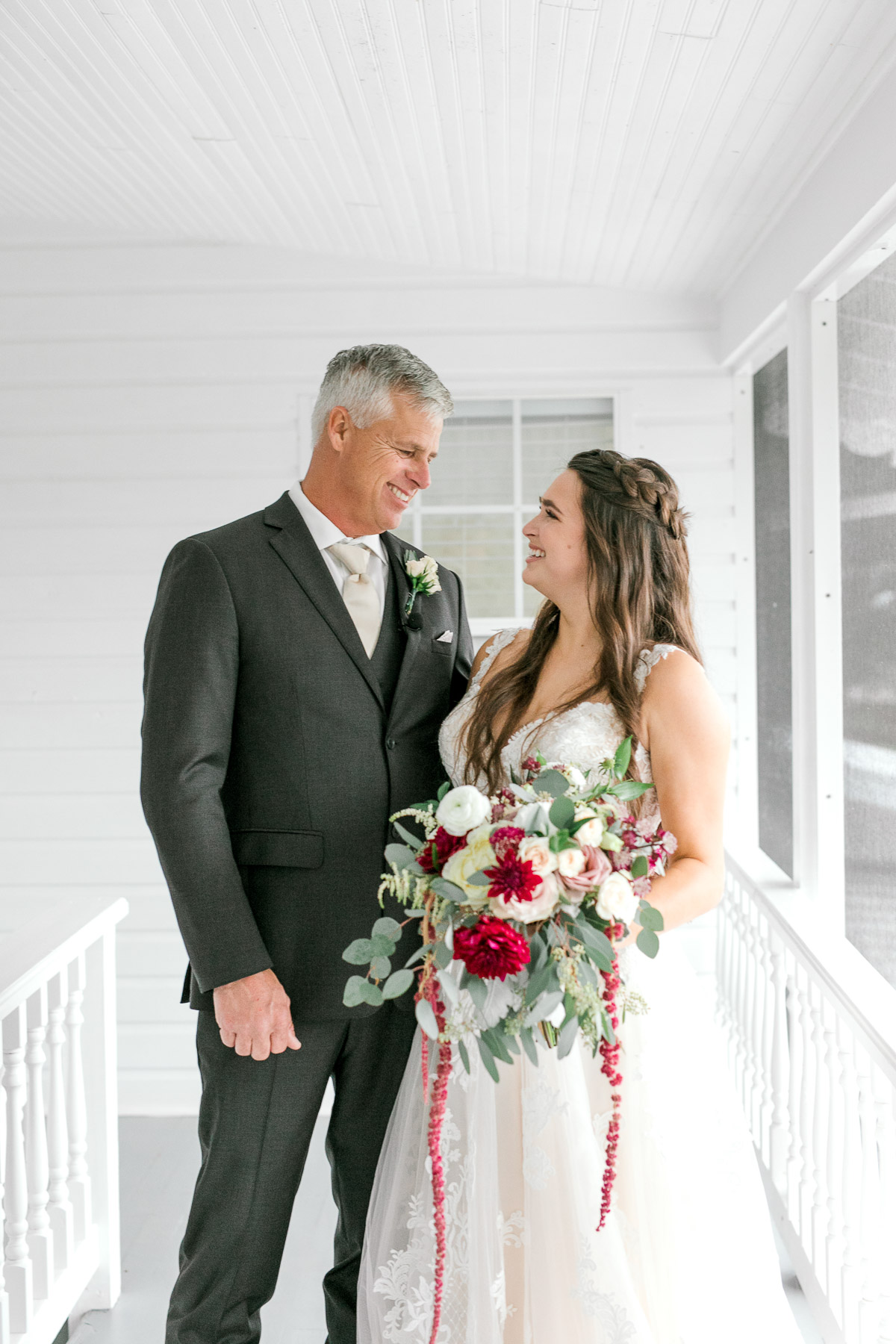 Father and daughter smile at each other at wedding