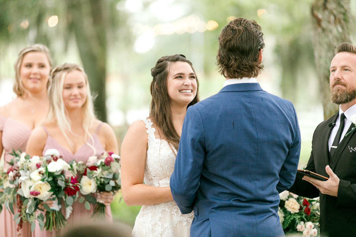 Bride smiles at groom during wedding ceremony