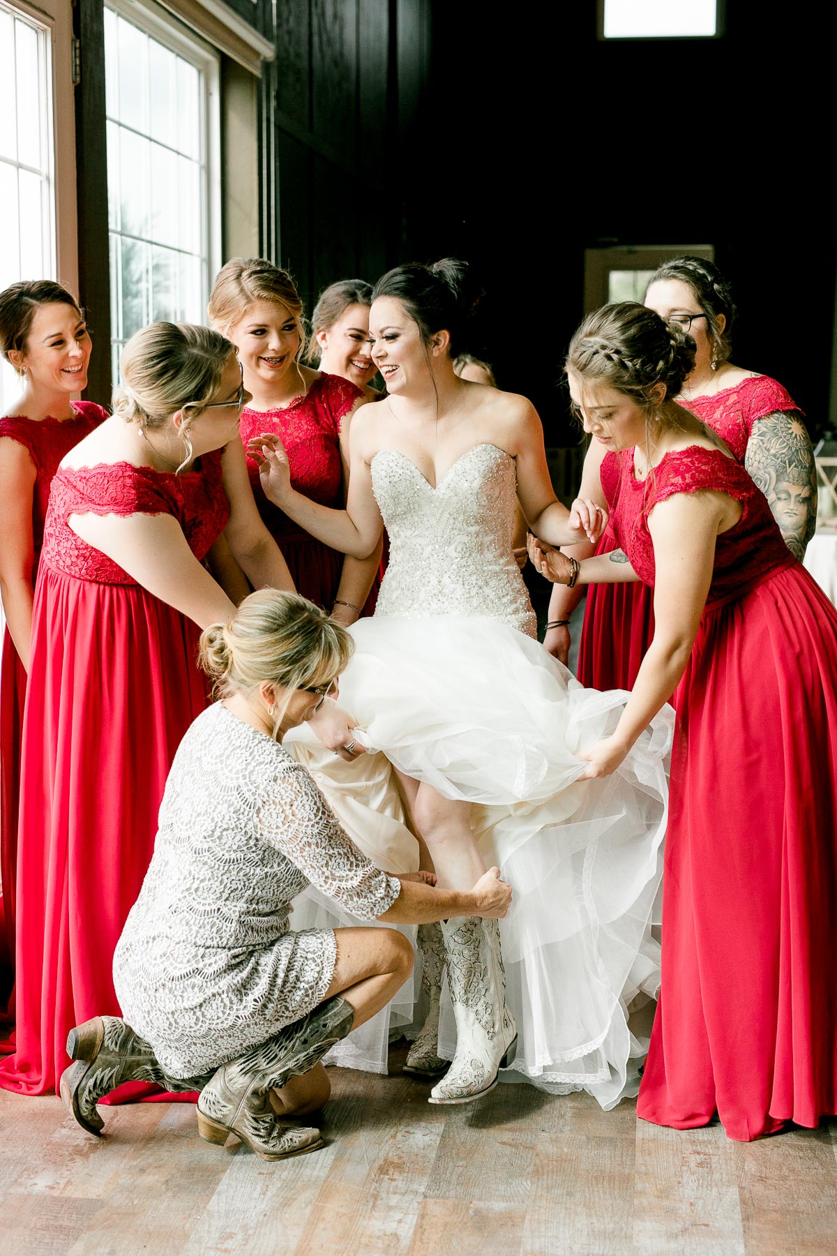 Bridesmaids helping bride into wedding boots