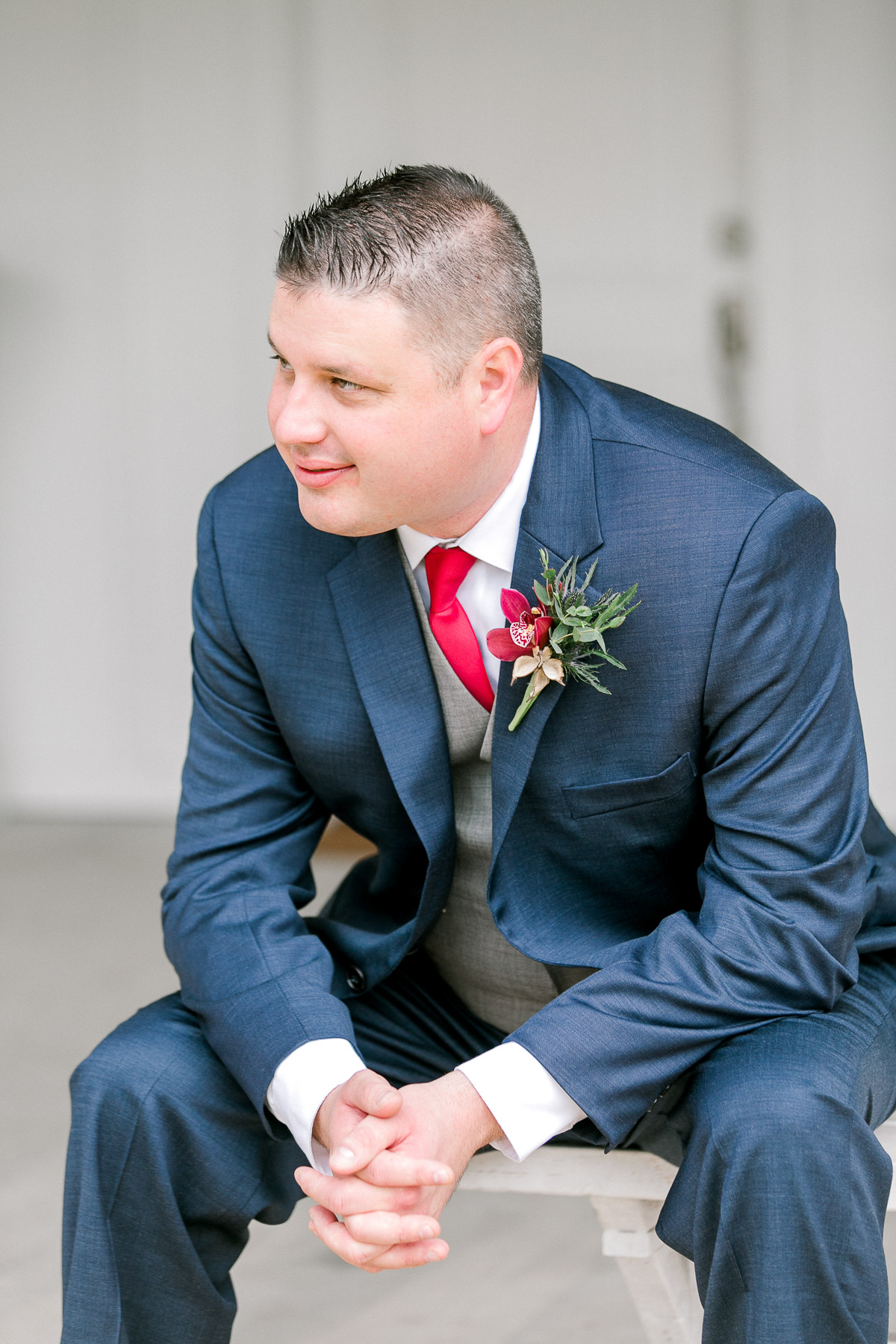 Groom in blue suit and red tie