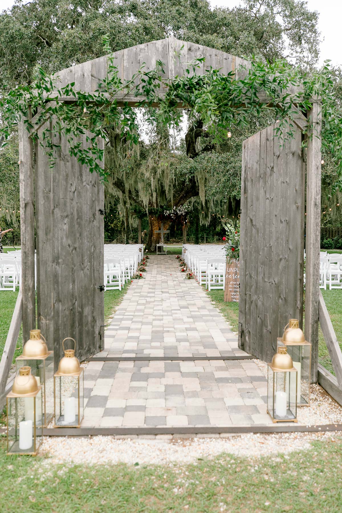 Rustic wooden doors opening to romantic outdoor wedding ceremony at Ever After Farms