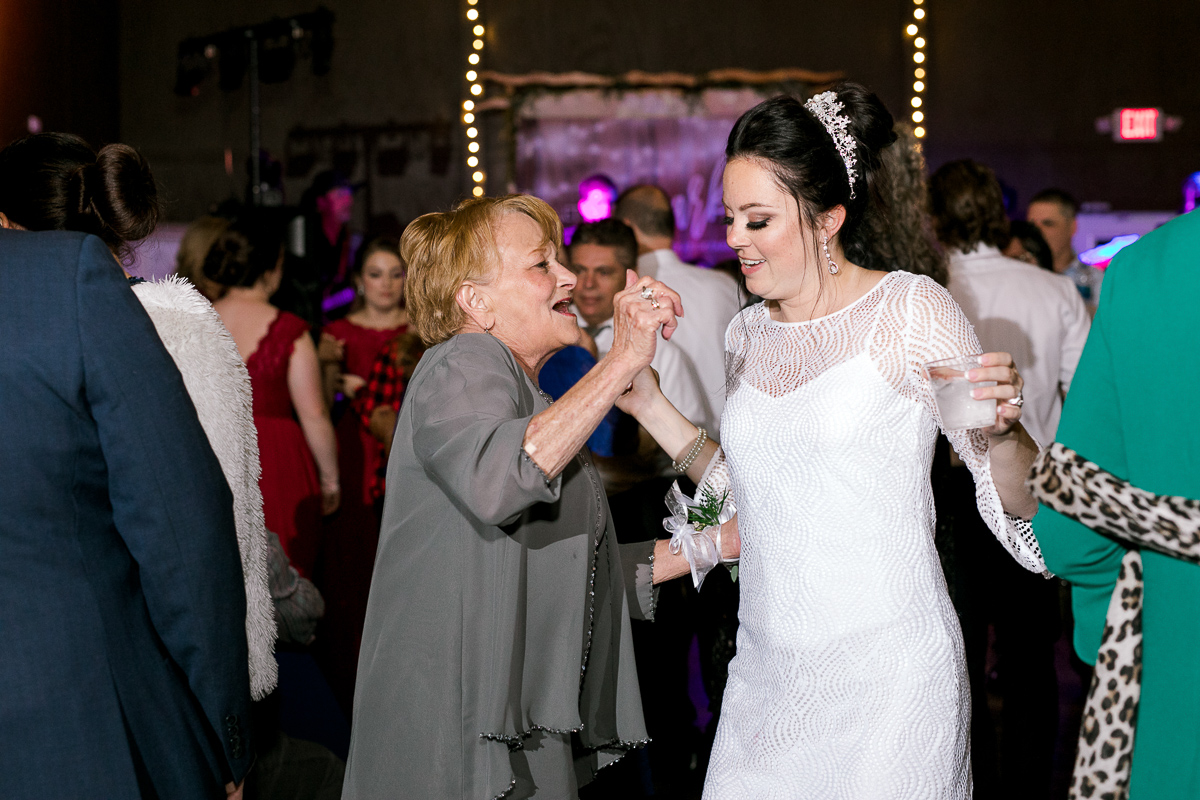 Bride dances with family member in beaded short reception dress