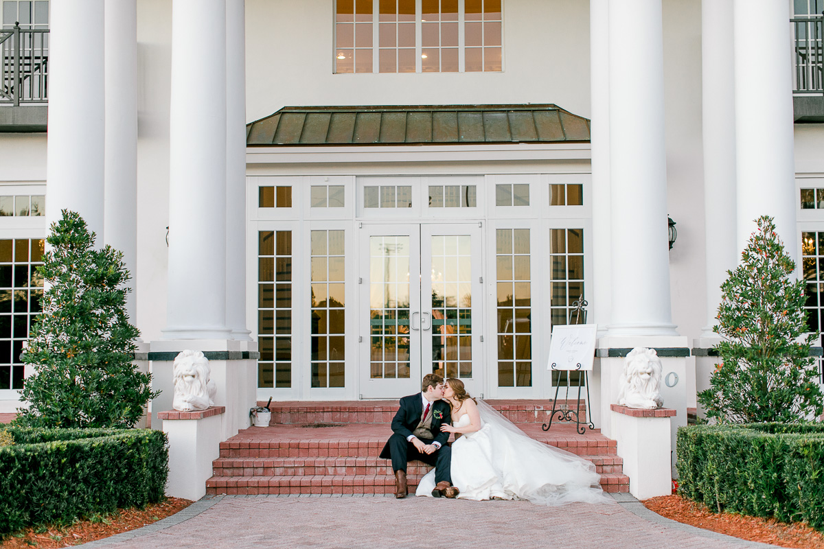 Bride and groom sitting on the steps of Luxmore Grande Estate 