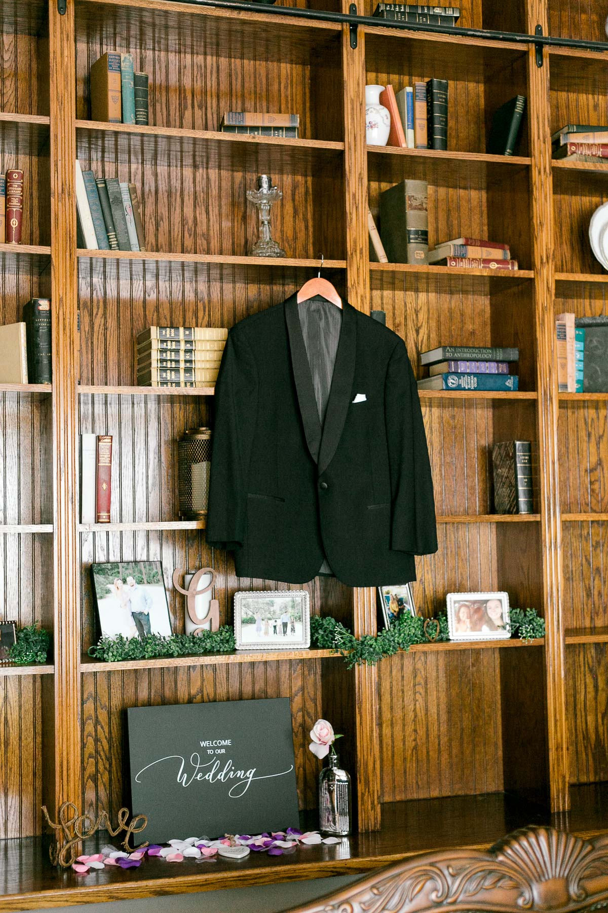 Groom's black tux hanging from the shelf in library at Luxmore Grande Estate