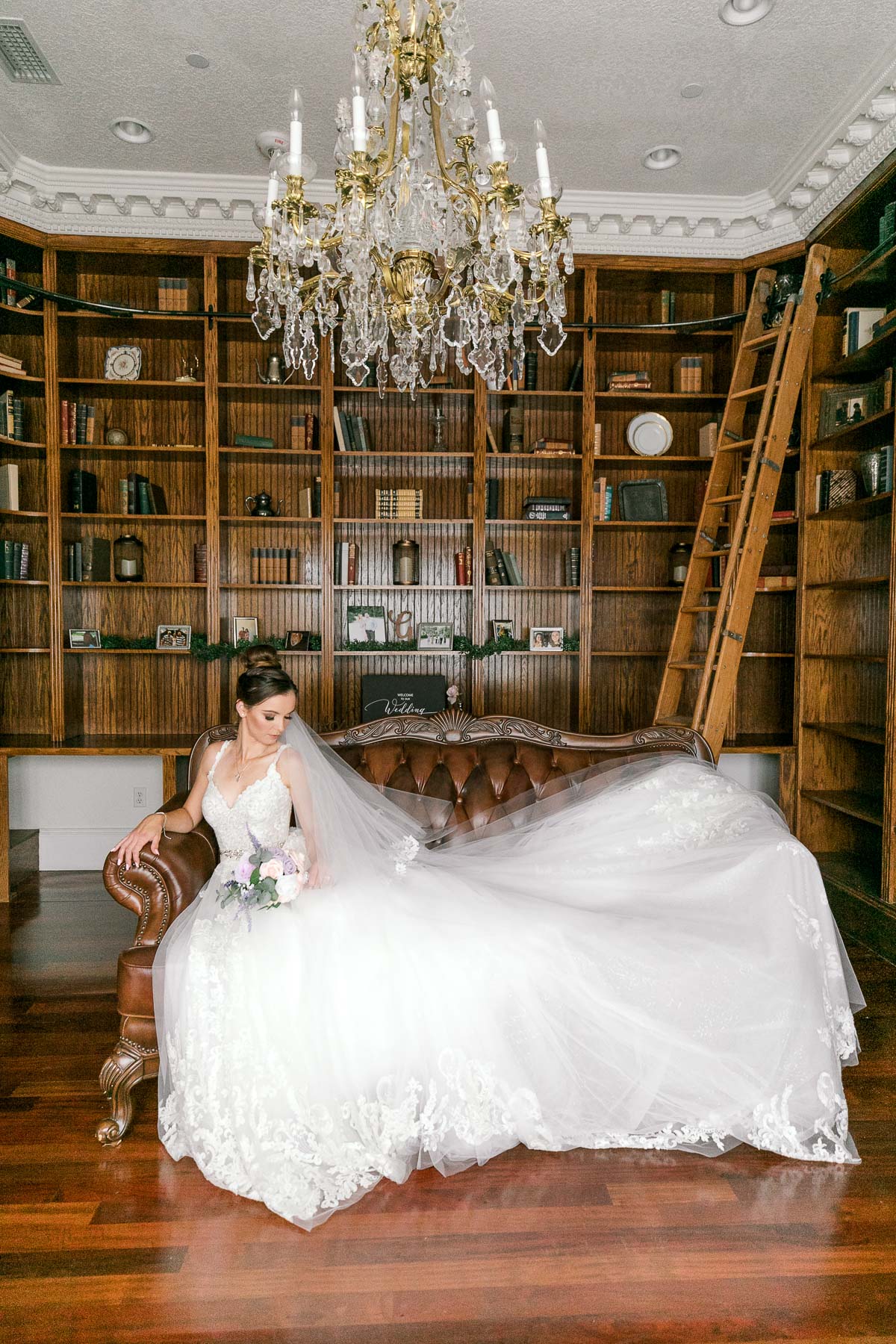 Bride posing on couch in Luxmore Grande Estate library 