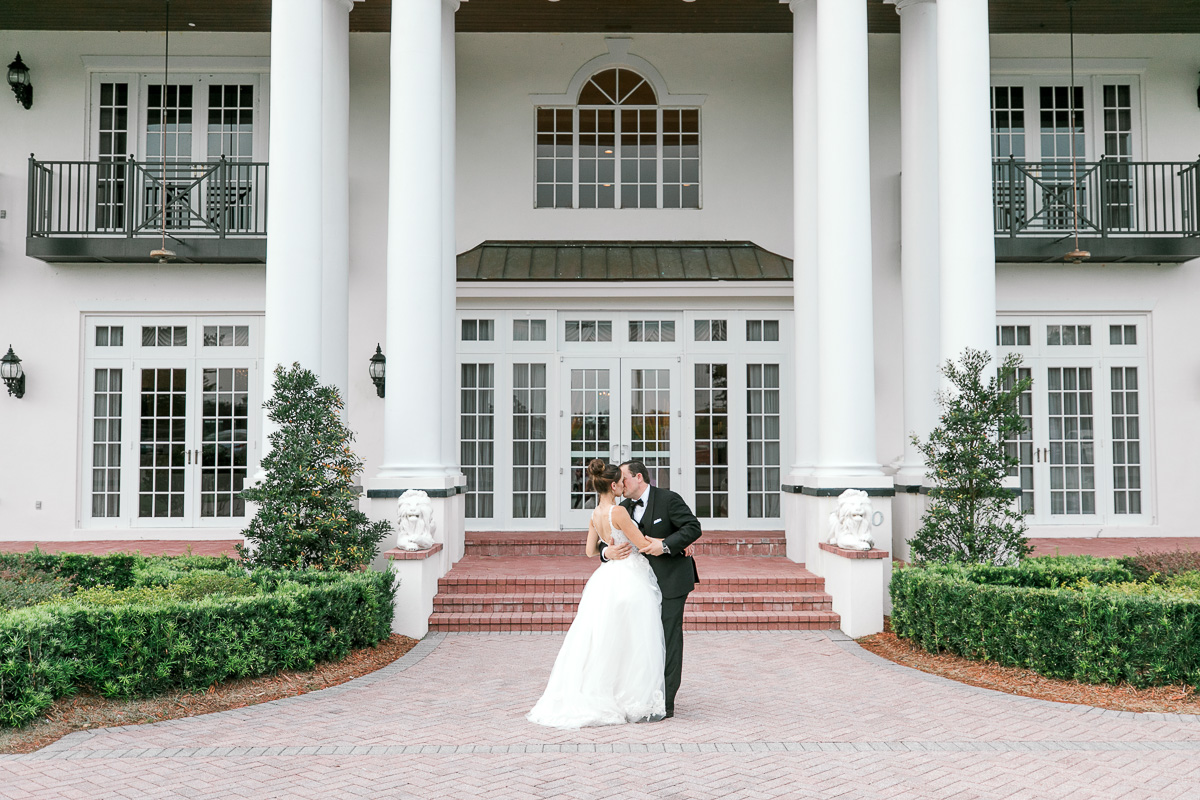 Bride and groom kiss in front of Luxmore Grande Estate