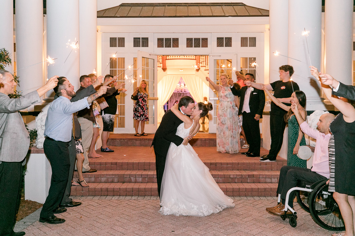 Bride and groom kiss at their sparkler exit 