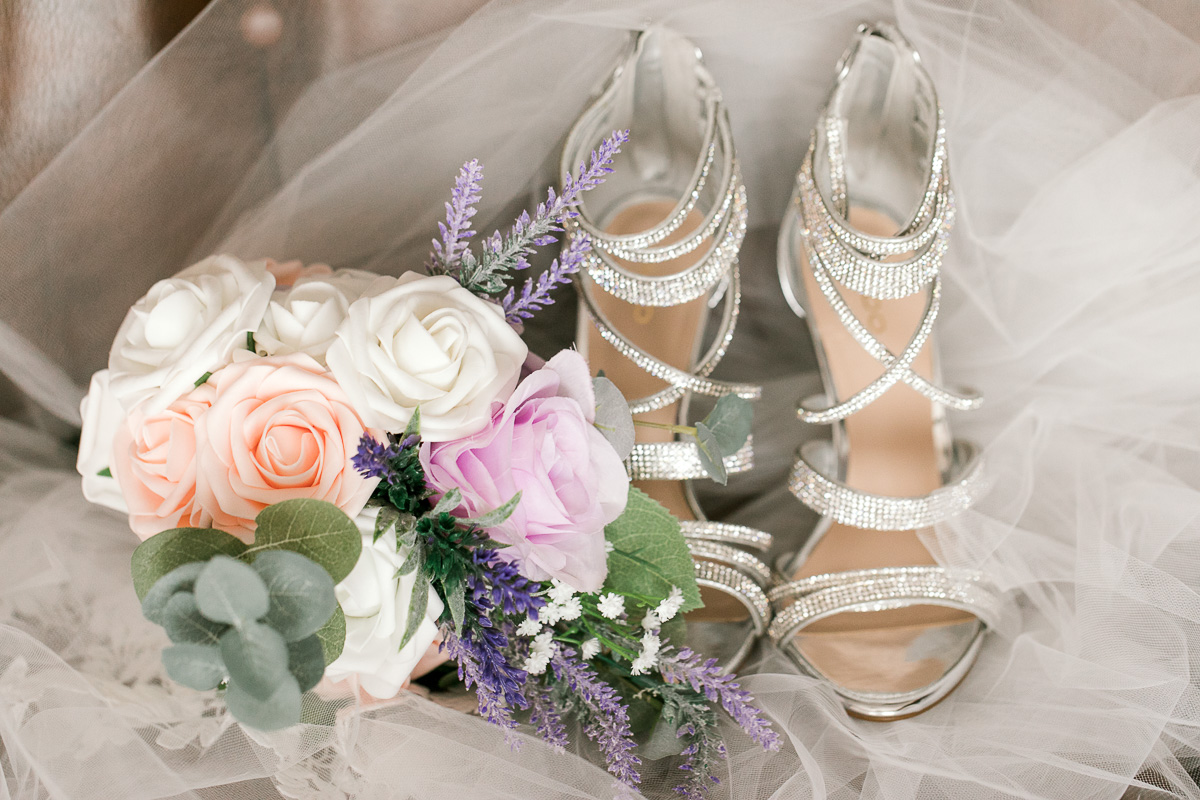 Silver wedding shoes and rose bouquet 
