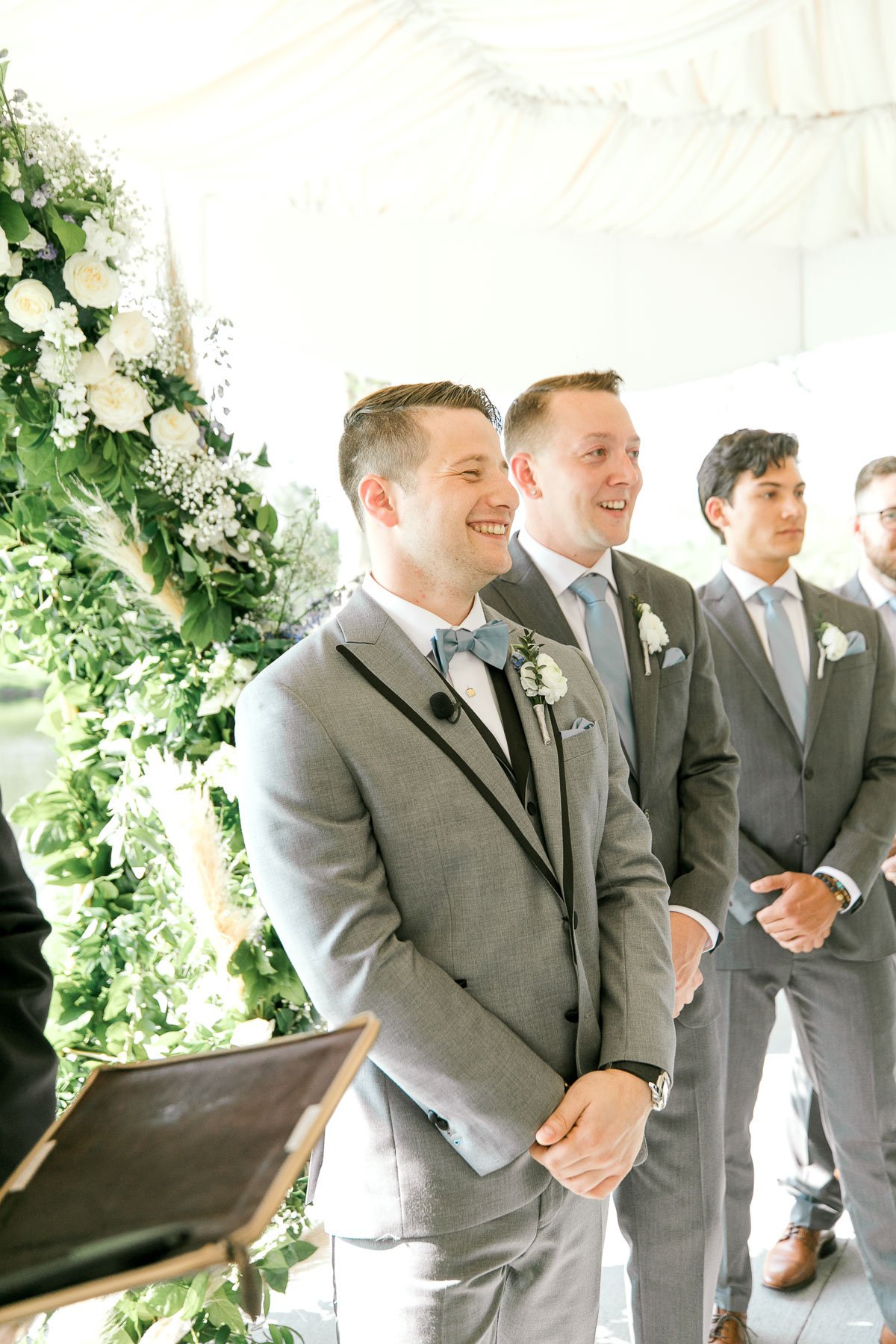 Groom smiling as he waits for bride to walk down the aisle.