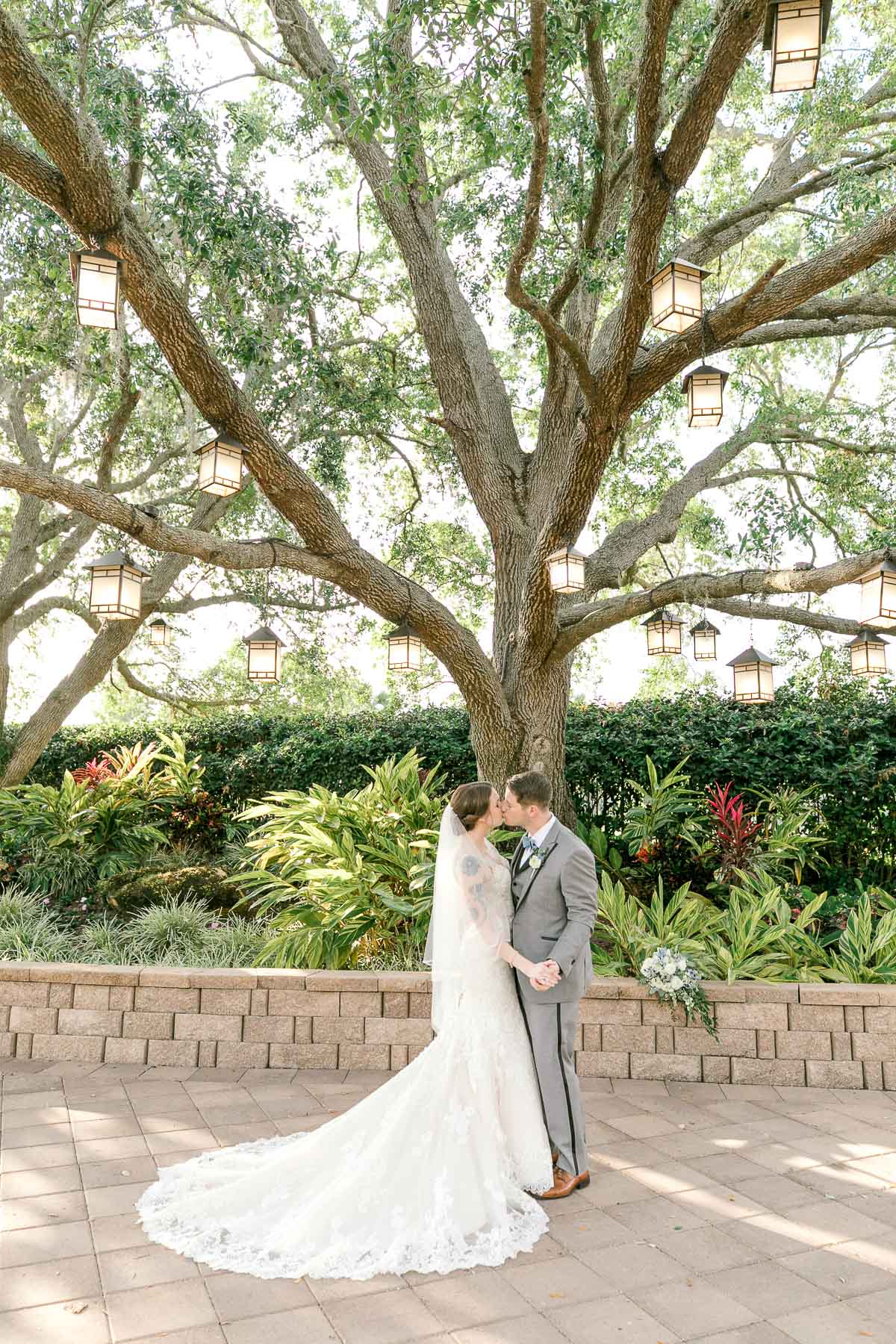 wedding portrait of bride and groom standing under tree