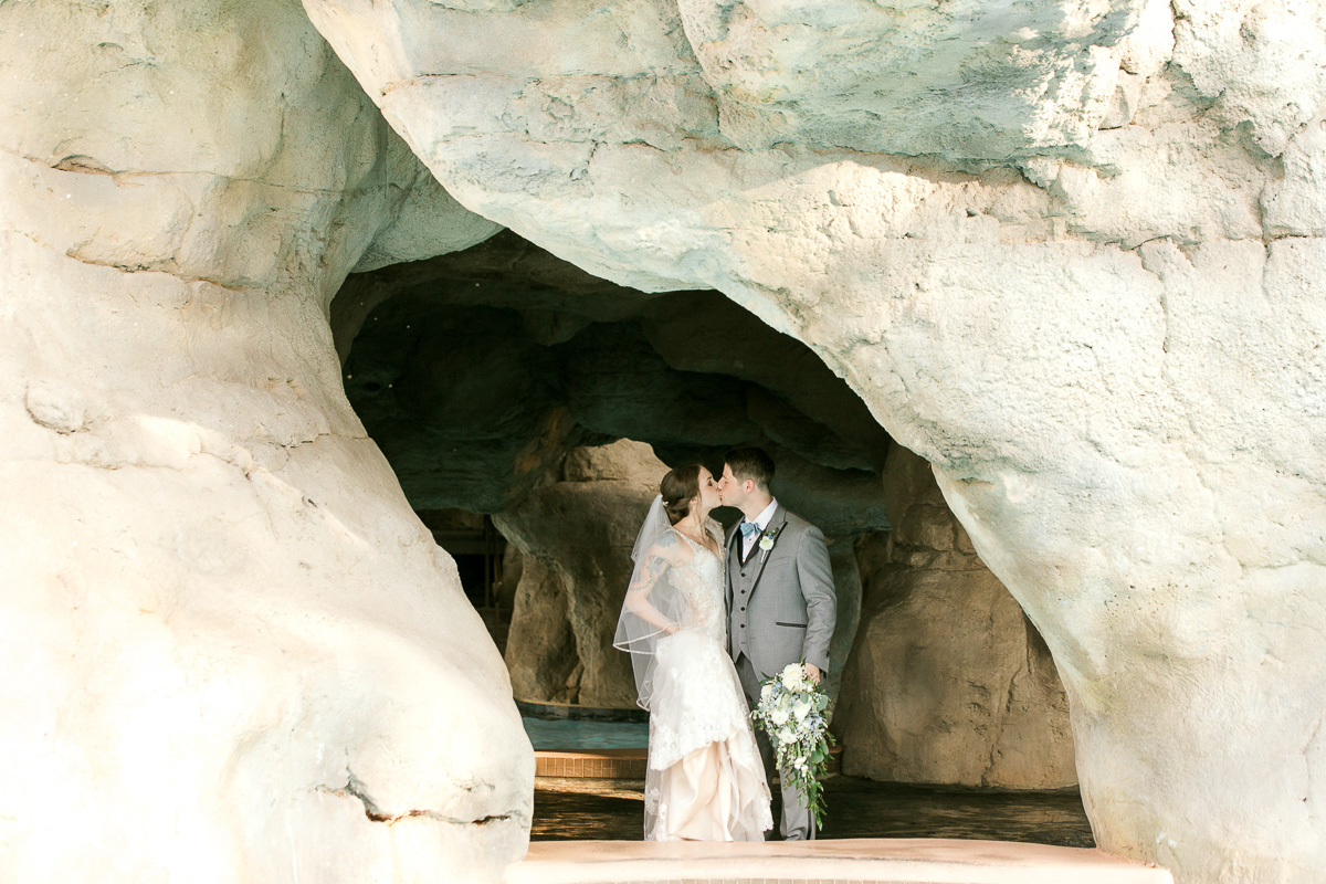 Bride and groom kissing in cave