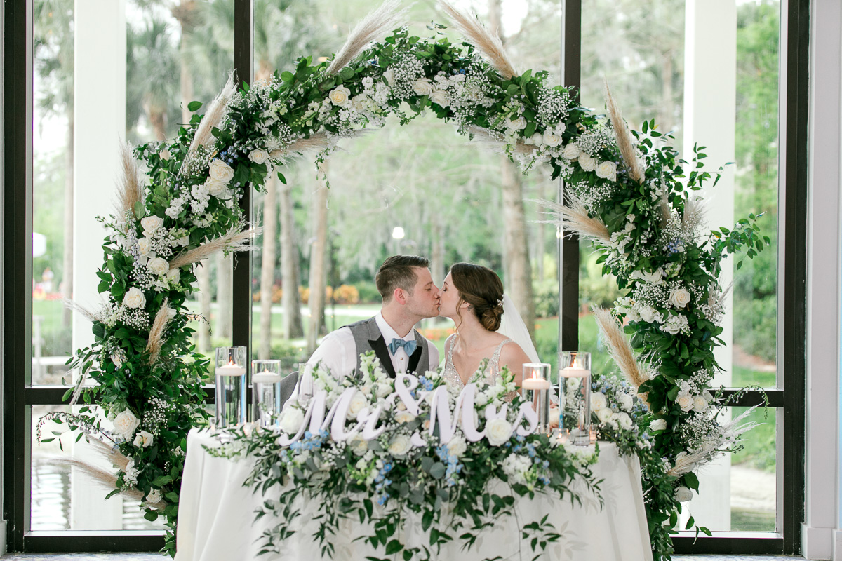 Wedding couple kiss at their sweetheart table