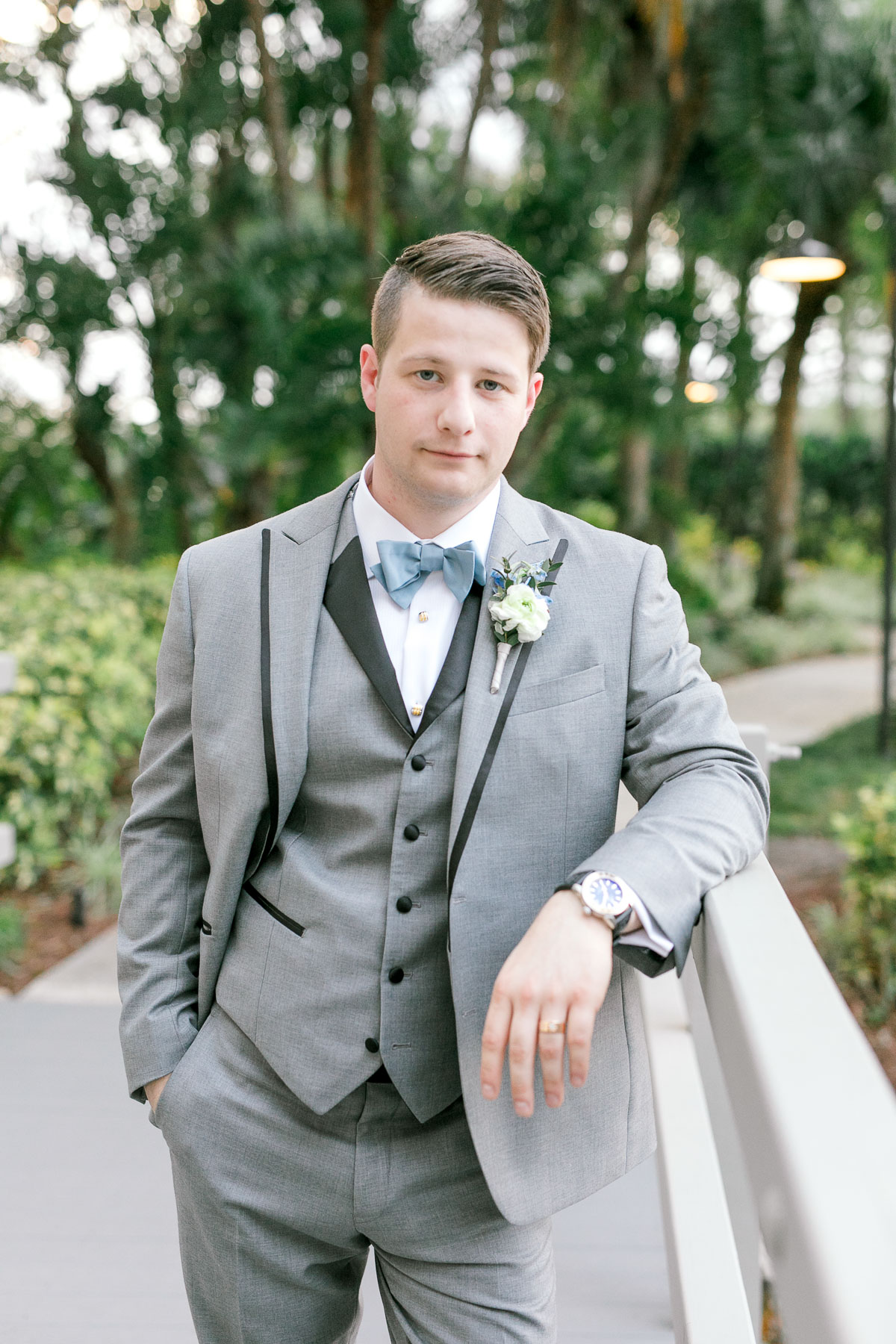 groom in gray tux with blue accessories