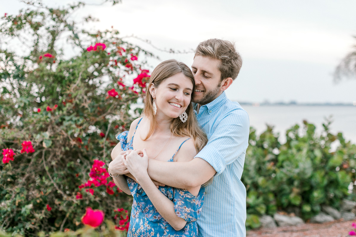 Couple in love laughing and hugging at their beachside engagement session